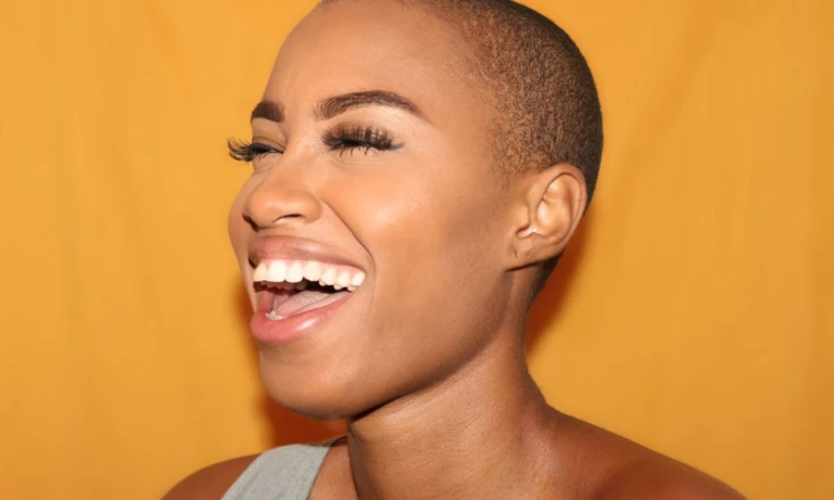Woman with alopecia laughing.